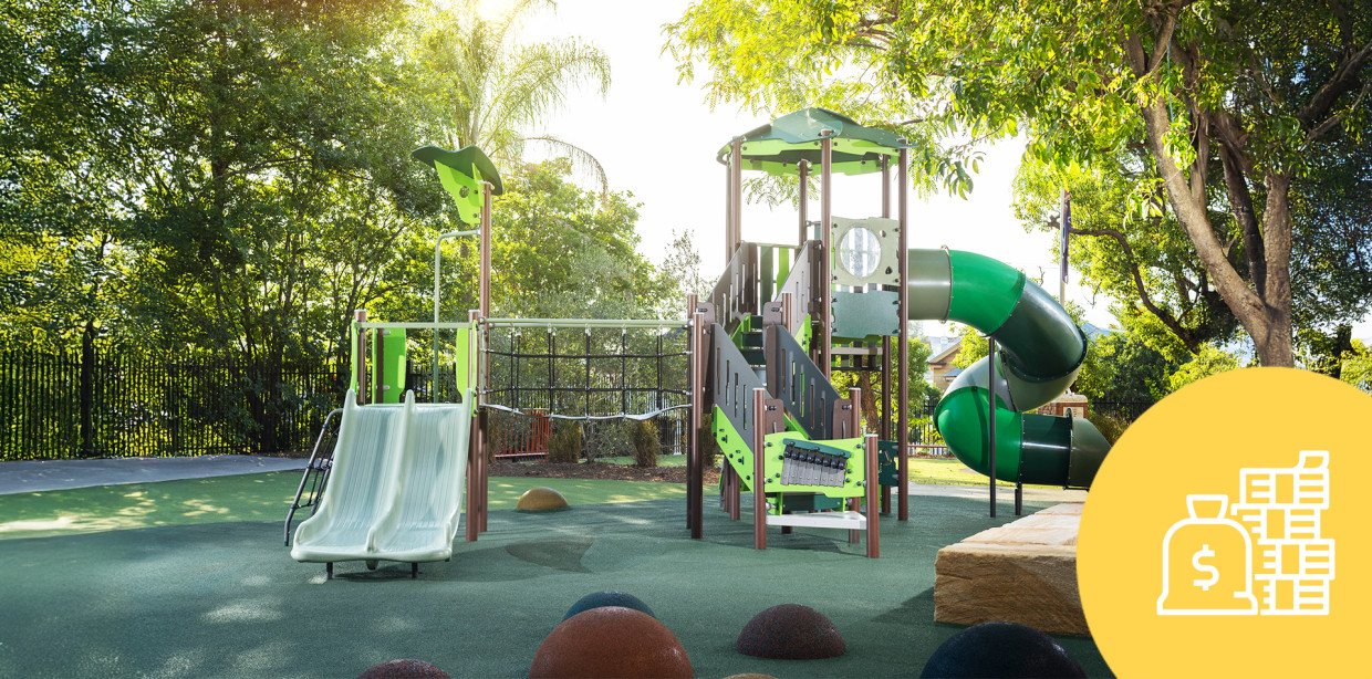 Commercial playground with slides, climbing equipment and shade in a landscaped park
