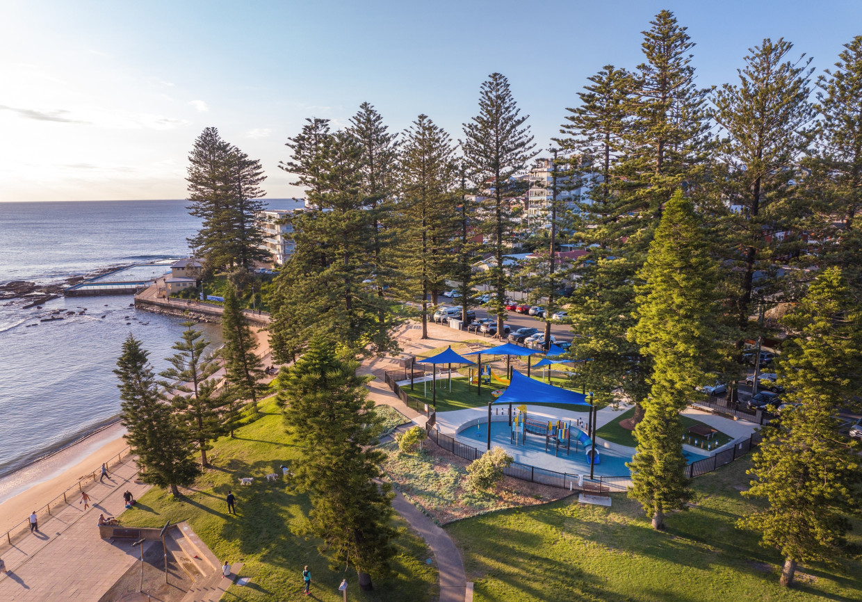 Aerial view of Michaela Howie Playground and its shade sails beside Dee Why beach